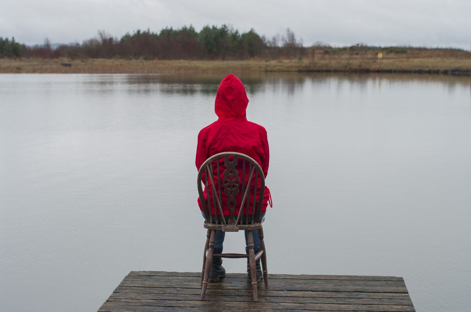 The figure seated in the middle of the jetty, facing the lough