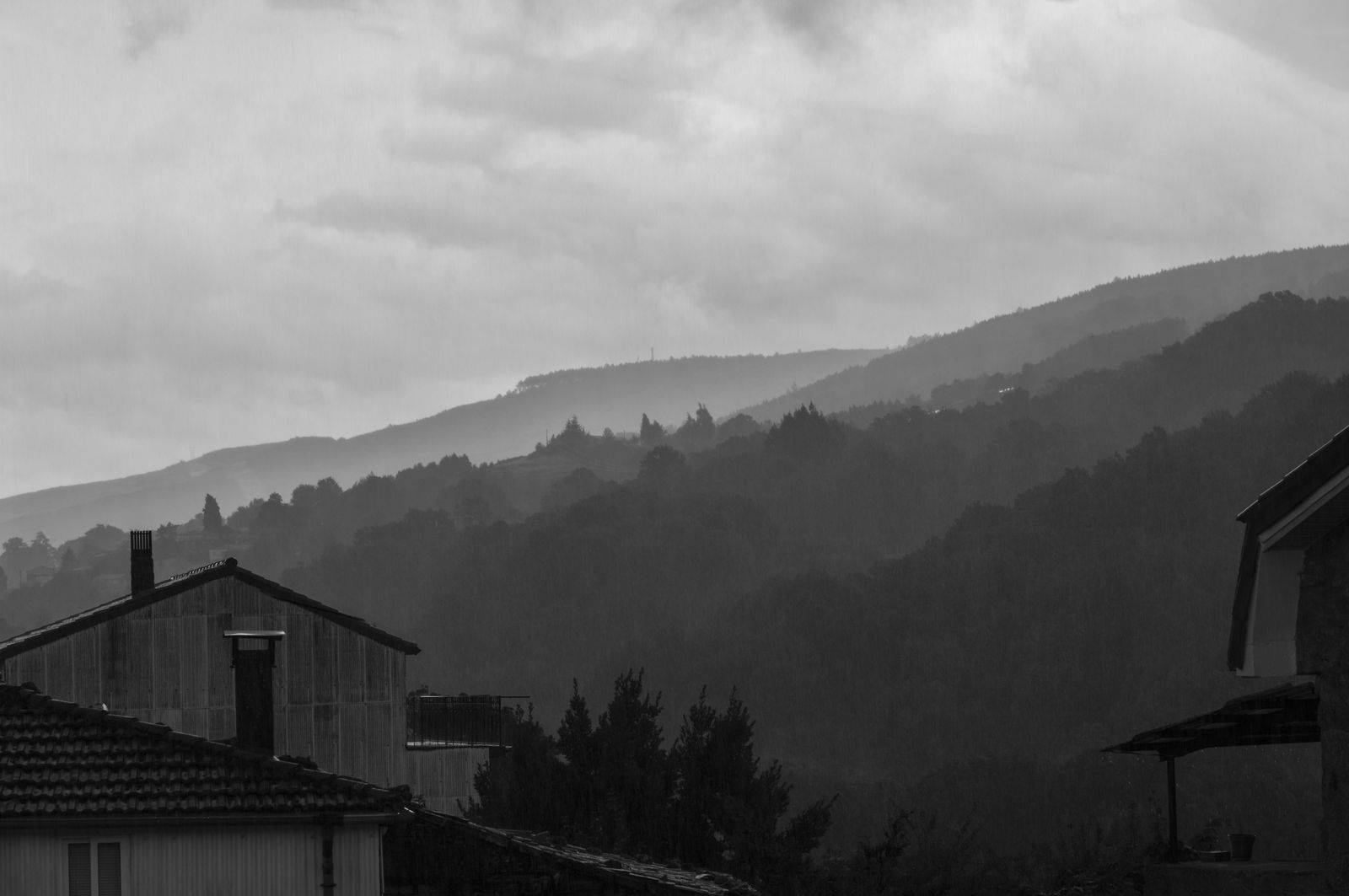 Lluvia sobre colinas y tejados, en blanco y negro