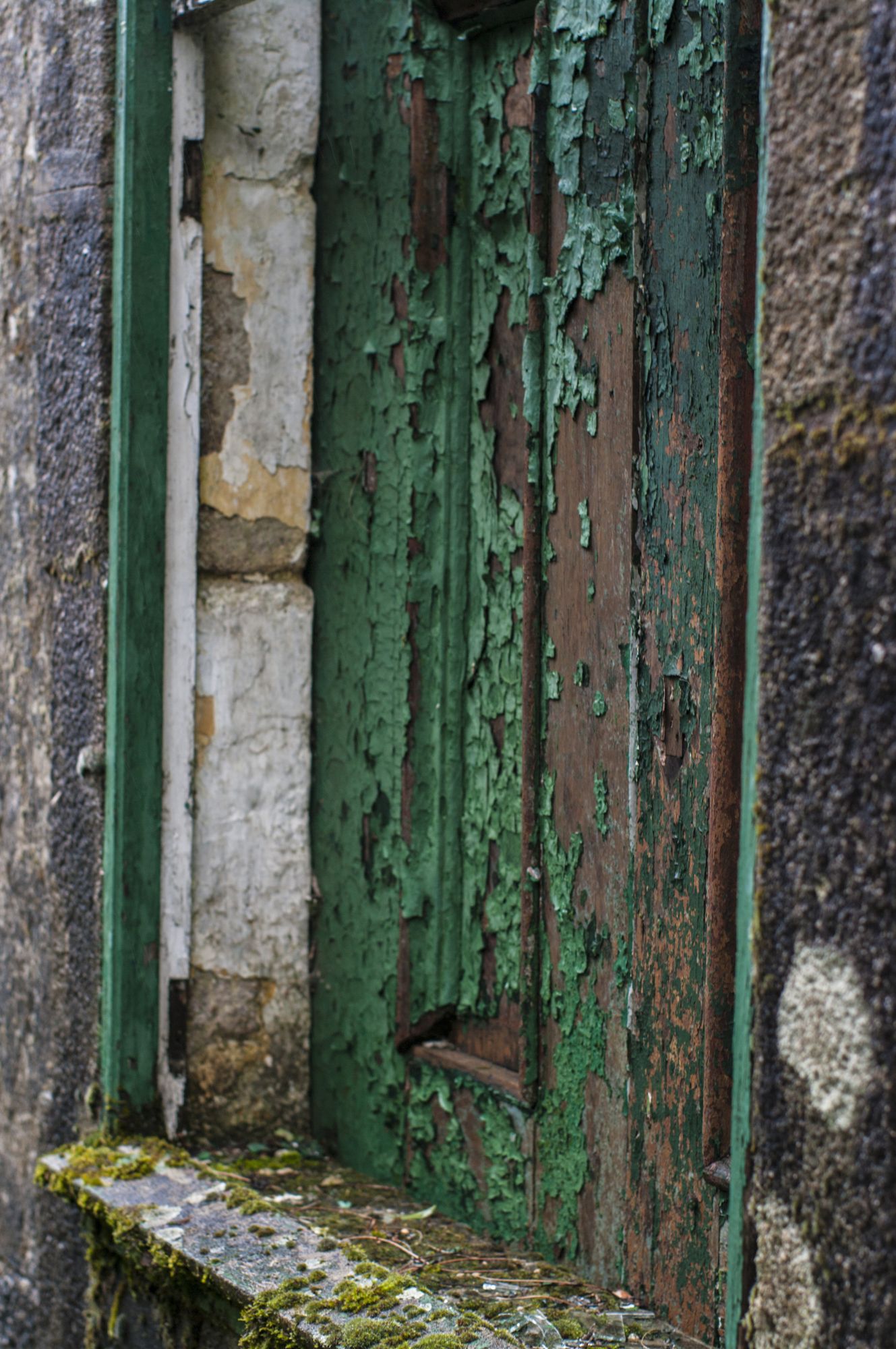 Un postigo que pierde la pintura verde